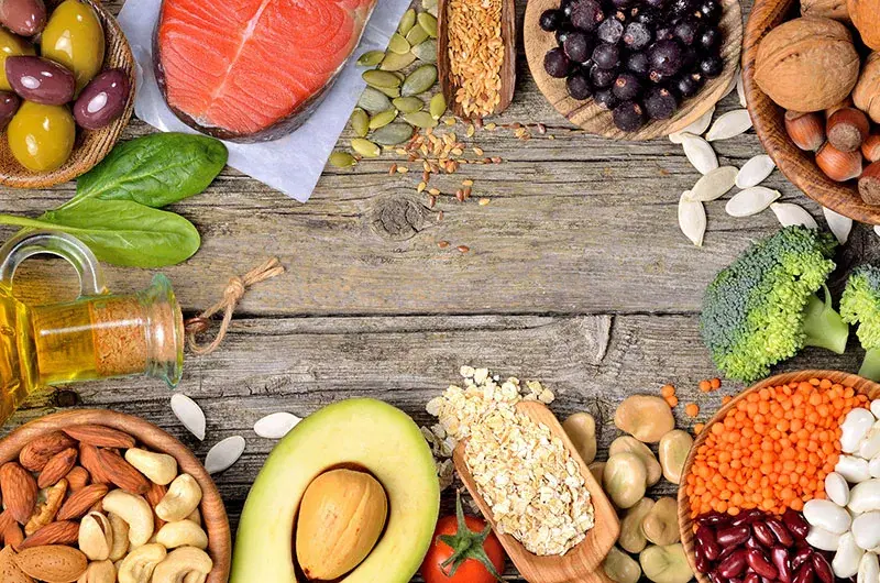 A spread of thyroid-supportive foods — salmon, seeds, greens, and nuts